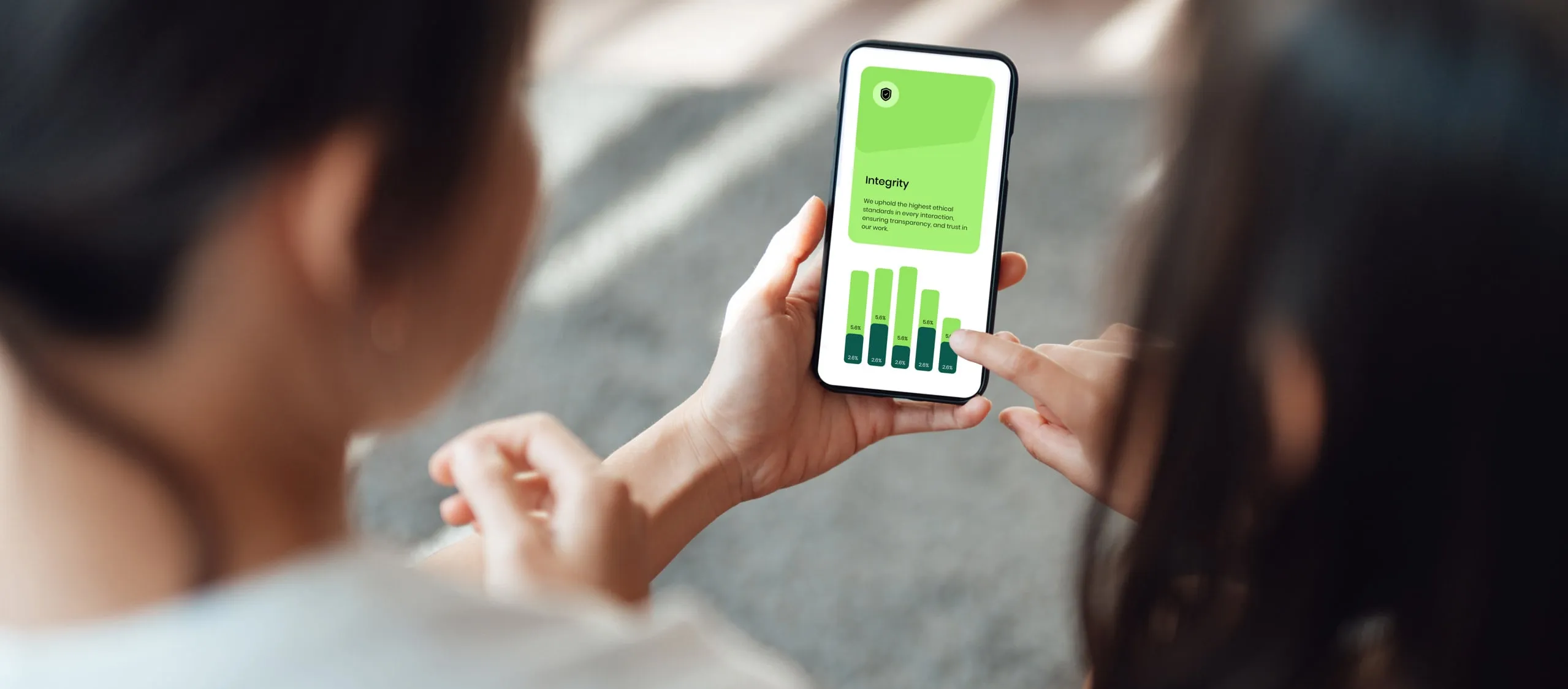 Two people looking at financial data on a smartphone.